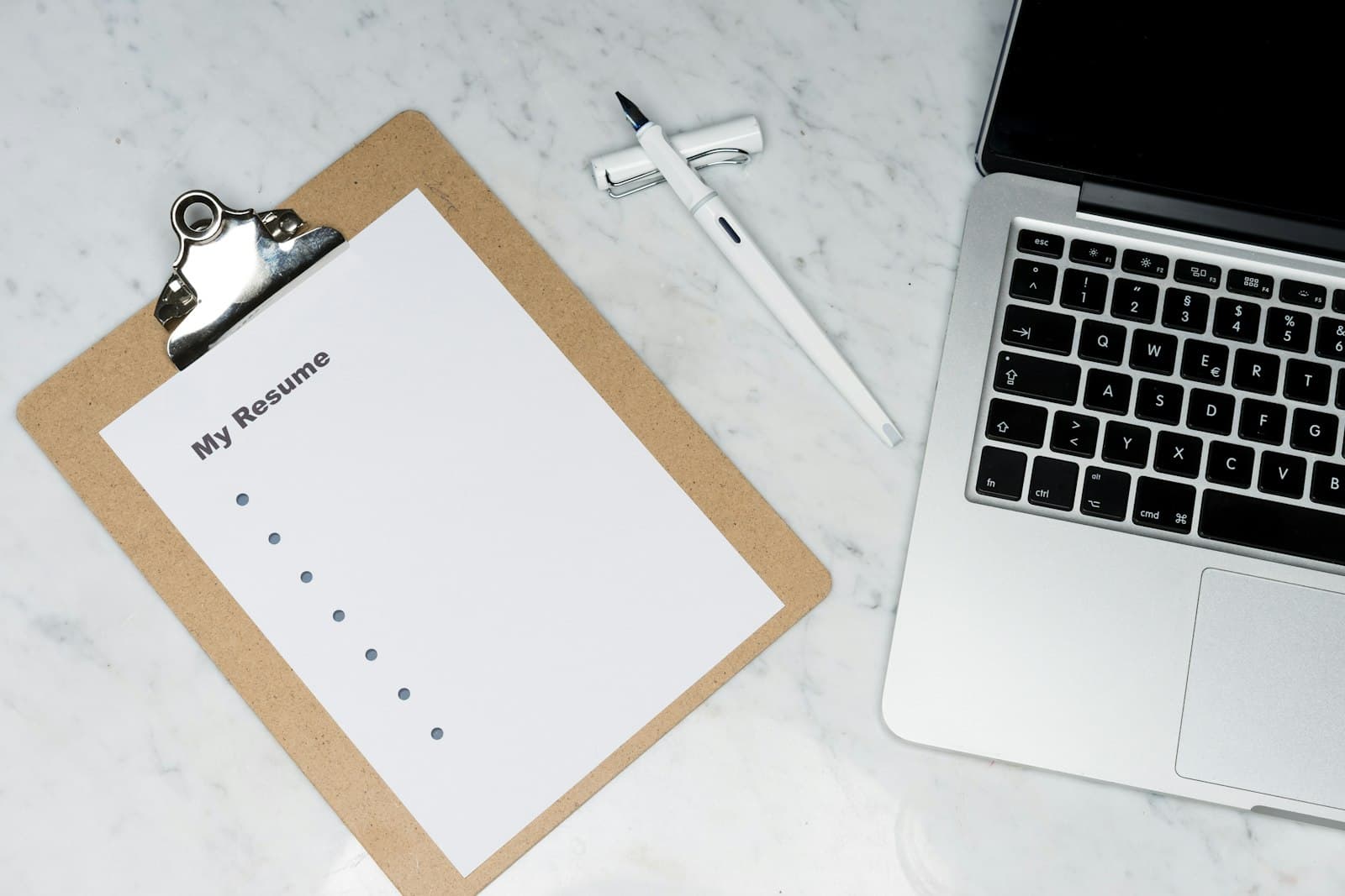 A printed contract on a desk next to a laptop